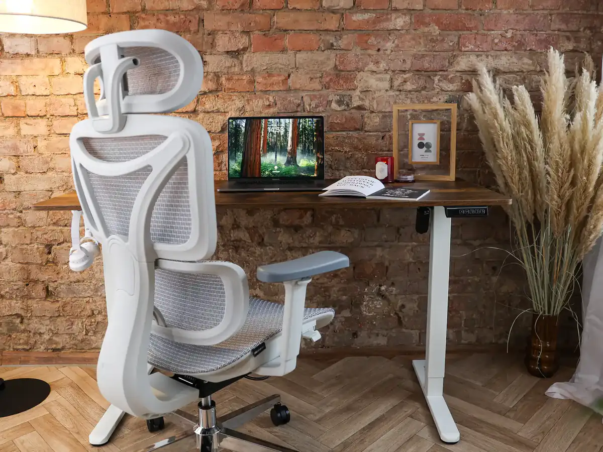 Biały fotel ergonomiczny z siatki i biurko regulowane z dębowym blatem – stanowisko do pracy w domu